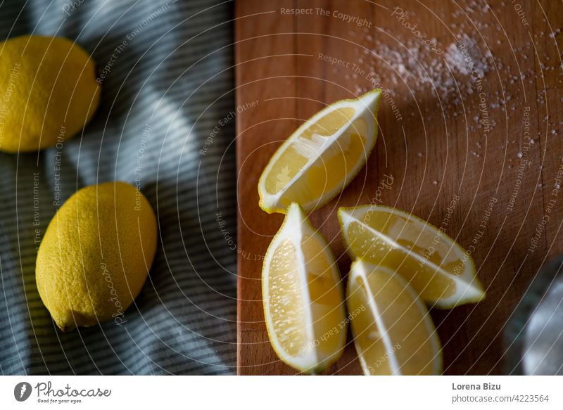 Volle Zitronen und halbe Zitronen auf einem Schneidebrett Viertel Zitronen Cutboard Zitrone schneiden Zitrone und Zucker Frucht gelb sauer frisch Früchte