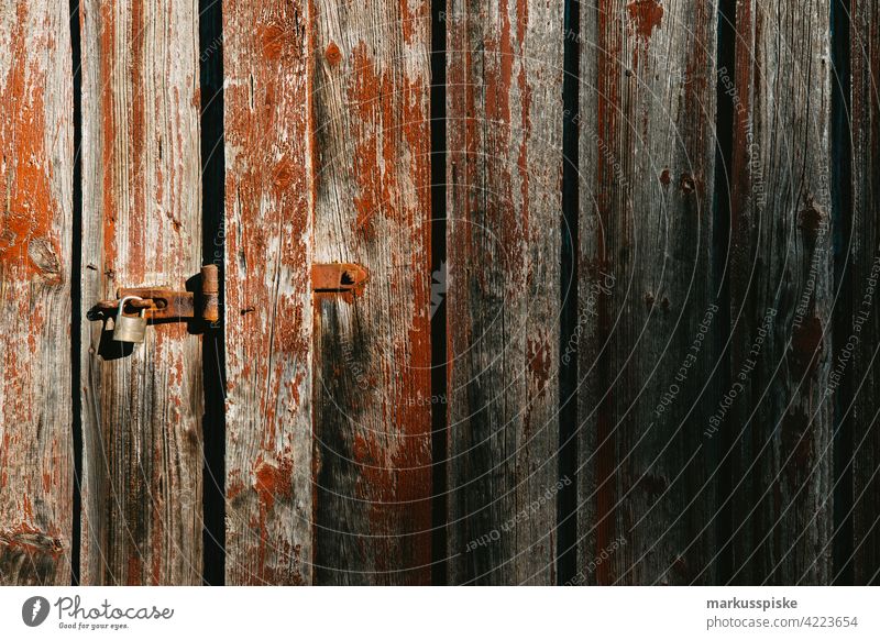 Scheunentor verschlossen Scheuentor Schloss verschlossene Tür Vorhängeschloss abgeblättert abgeblätterte Farbe holztor verwittert verwittertes Holz Verwitterung