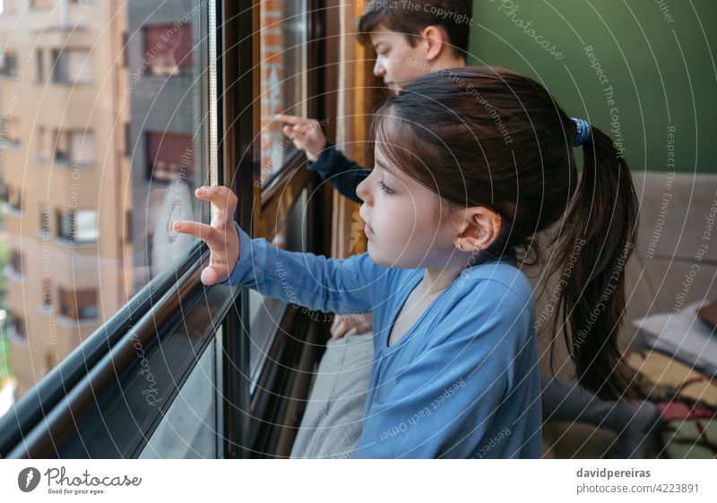 Zwei Kinder in Coronavirus-Sperre malen am Fenster Mädchen Sperrung Schreiben mit dem Finger Spielen langweilig heimwärts Quarantäne Appartement Homewear