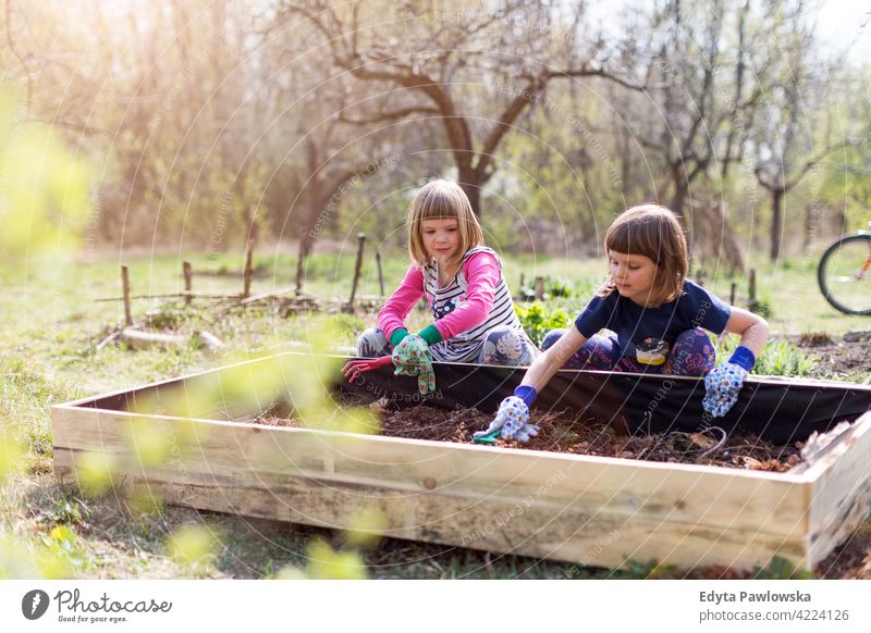 Zwei kleine Mädchen bei der Gartenarbeit im städtischen Gemeinschaftsgarten Bewässerung Gießkanne Wasser städtischer Garten Umweltschonung