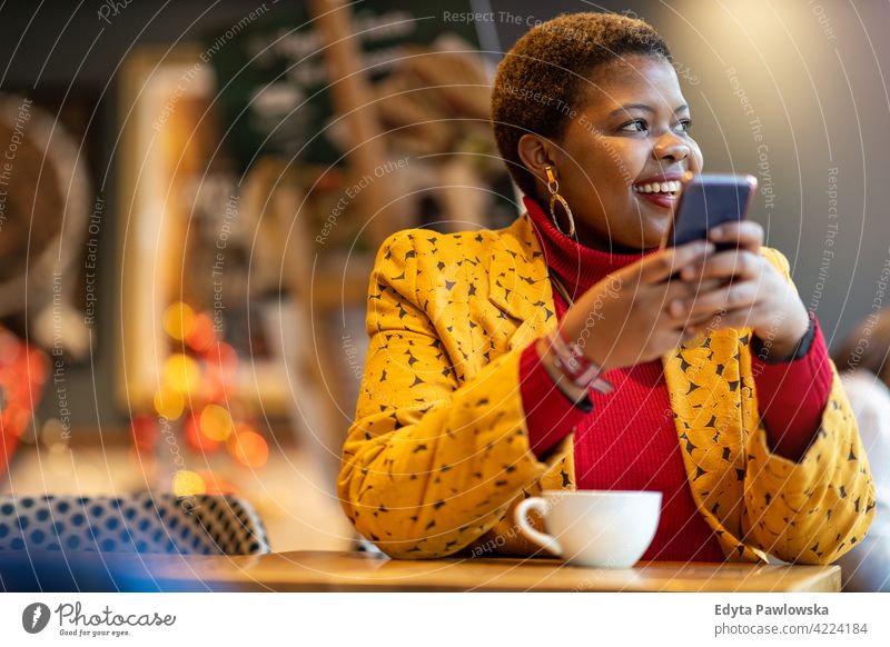 Glückliche junge Frau mit Smartphone in einem Café Kaffee Restaurant Kaffeehaus Positivität selbstbewusst sorgenfrei Menschen Erwachsener lässig schön attraktiv