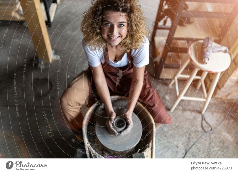 Frau macht Keramikarbeit mit Töpferscheibe Töpferwaren Künstler Kunst Arbeit arbeiten Menschen jung Erwachsener lässig attraktiv Glück Kaukasier genießend
