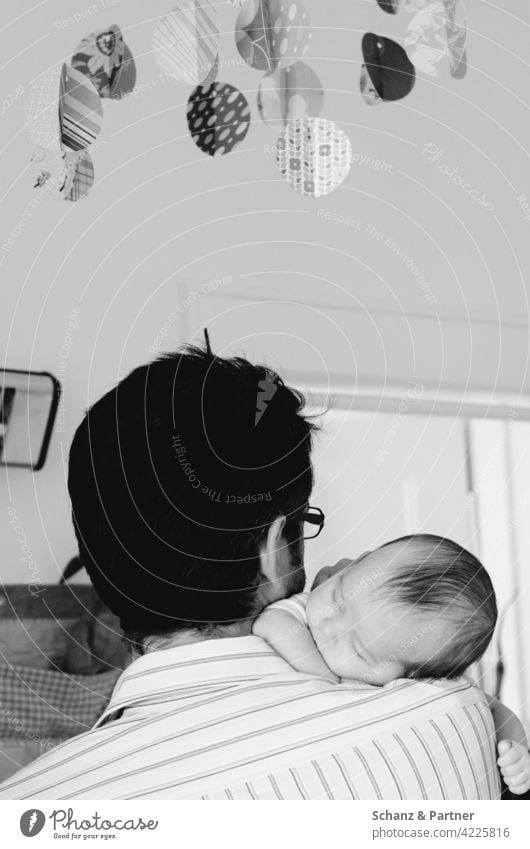 Papa mit Baby auf dem Arm eingeschlafen Kleinkind einschlafen Eltern Papa werden Elternzeit Papa und Kind Vater Vaterschaft Mobile Kinderzimmer wickeln niedlich