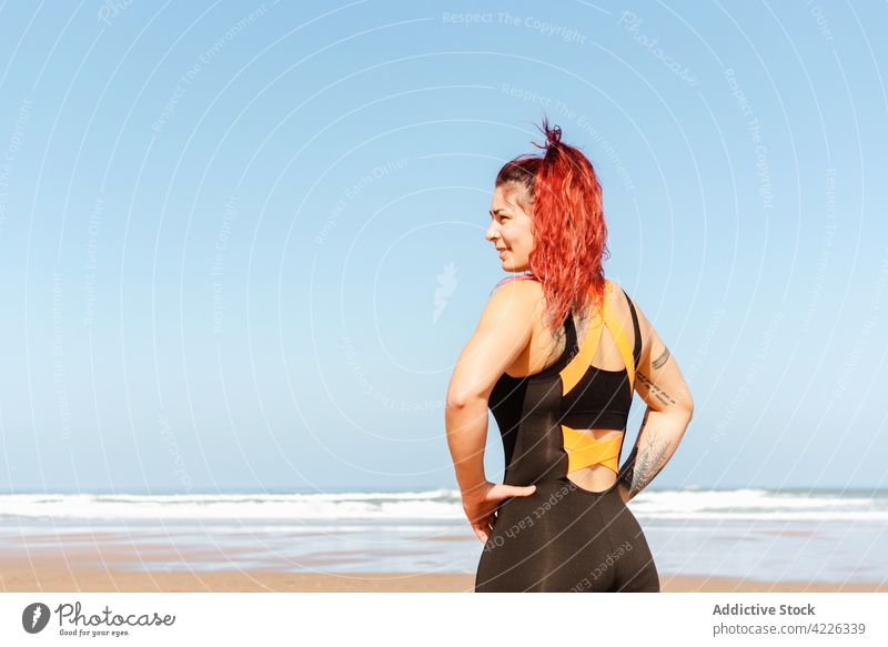 Selbstbewusste Sportlerin mit Tattoos an der Meeresküste selbstsicher zufrieden sportlich Individualität nachdenken Meeresufer Porträt Frau Athlet selbstbewusst