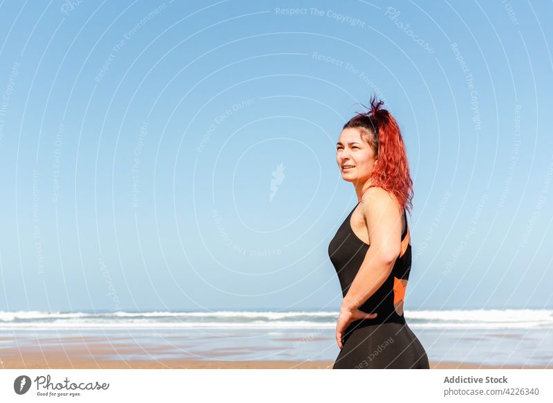 Selbstbewusste Sportlerin mit Tattoos an der Meeresküste selbstsicher zufrieden sportlich Individualität nachdenken Meeresufer Porträt Frau Athlet selbstbewusst