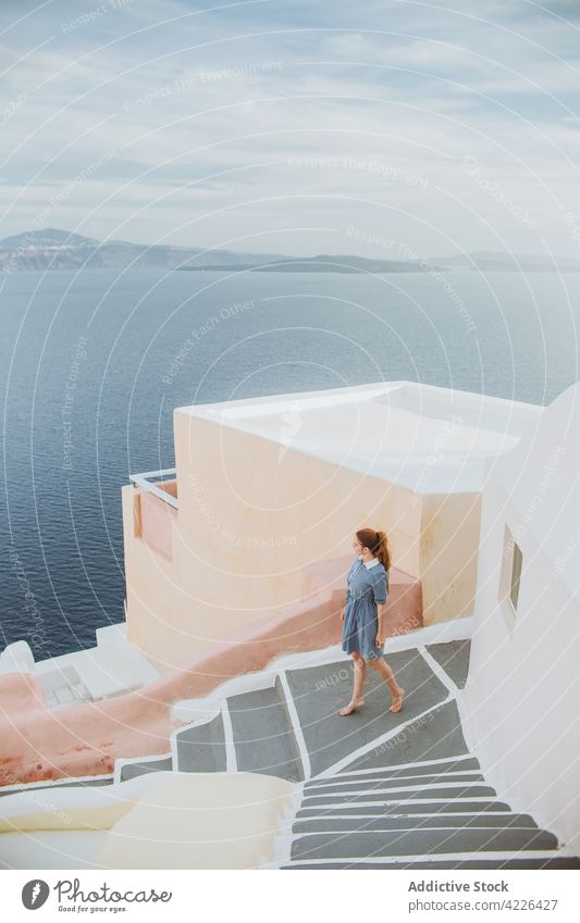 Unbekannte Frau steht auf einer Steintreppe in einem Küstendorf Treppenhaus MEER Küstenstreifen Stadt Dorf Dorf Oia Schritt Architektur Meeresküste Tourist
