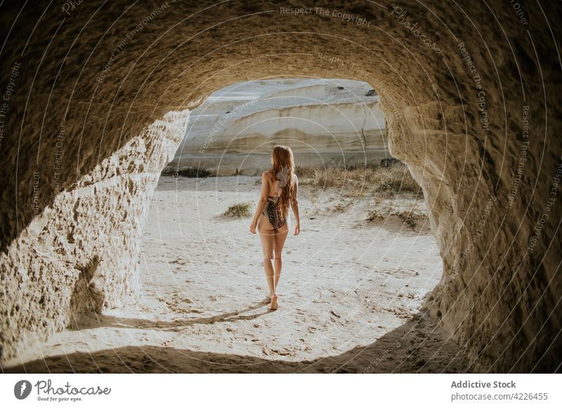 Anonyme Frau in Badekleidung in der Nähe einer steinernen Höhle stehend Badebekleidung reisen passen sonnig Natur Resort erkunden Sonnenbad Bräune sarakiniko