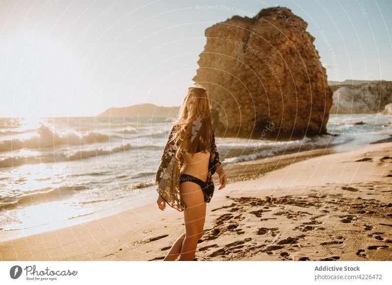 Unerkennbare fitte Frau im Badeanzug am Sandstrand stehend Kälte Strand Meeresufer Felsen Resort Paradies schlank Sonnenbad Natur fyriplaka Milos Griechenland