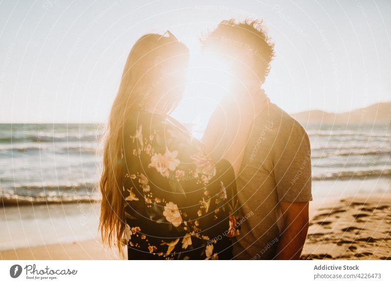 Junges Paar, das sich an der sonnigen Felsenküste umarmt Umarmung Meeresküste verliebt Partnerschaft Natur Strand Flitterwochen romantisch Resort Umarmen