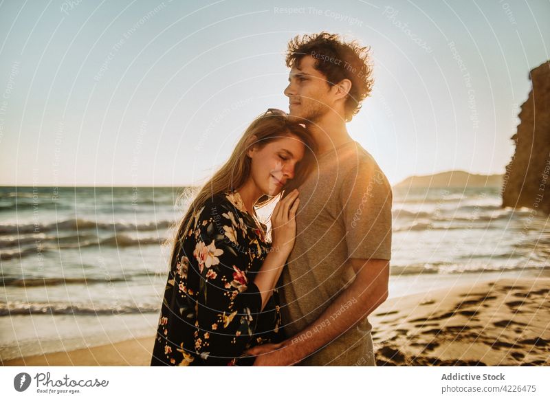 Junges Paar, das sich an der sonnigen Felsenküste umarmt Umarmung Meeresküste verliebt Partnerschaft Natur Strand Flitterwochen romantisch Resort Umarmen