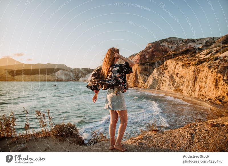 Unerkennbare Frau an malerischer Felsküste stehend Meeresufer felsig Natur Haare berühren Resort Küstenlinie feminin Klippe fyriplaka bewundern Reisender Felsen