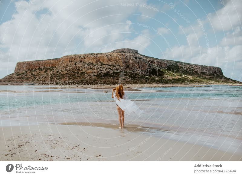 Attraktive Frau in Badekleidung steht am sandigen Meeresufer Kälte Balos Strand Badeanzug Felsen Resort Paradies malerisch Bräune ruhen Bikini Crete schlank