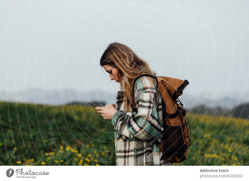 Rucksacktourist mit Navigations-App auf dem Smartphone auf dem Lande Wanderer Feld Gps Anwendung Route Regie Frau benutzend Apparatur Gerät Landschaft