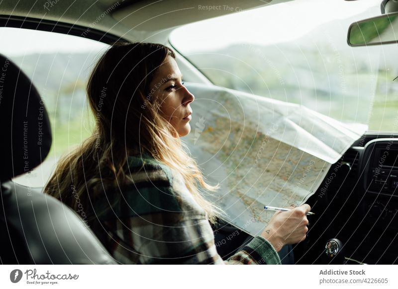 Fahrer mit Karte im Auto während der Fahrt Landkarte Route Örtlichkeit Ausflugsziel Anleitung sich orientieren Frau PKW Reisender Landschaft Fernweh Tourist
