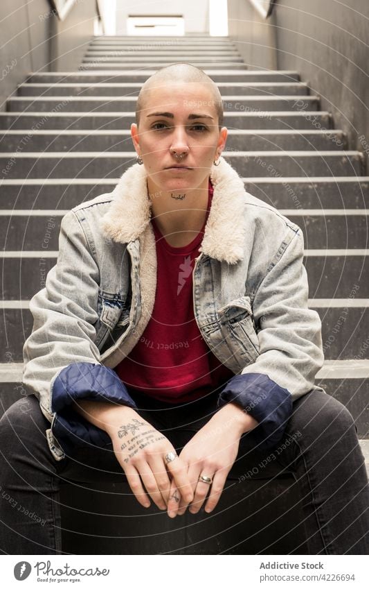 Queer mit verschränkten Händen auf der Treppe liegend queer Hände gefaltet Individualität cool Streetstyle akzeptieren Identität Geschlecht Porträt Transgender