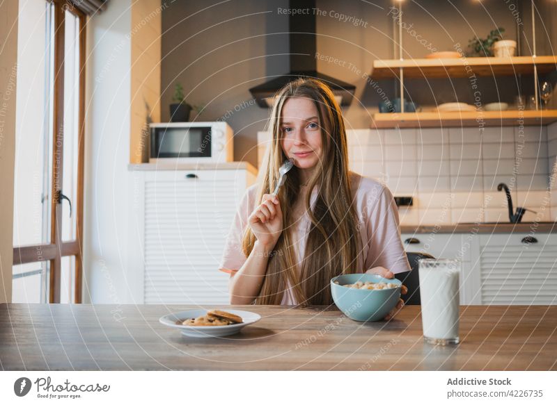 Frau isst leckeres Müsli zum Frühstück zu Hause essen Mais Ring süß Ernährung Mund geöffnet Porträt Küche heimwärts Portion Tisch heimisch Löffel