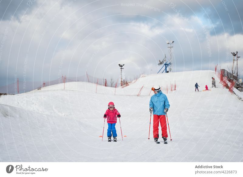 Unerkanntes Elternteil und Kind beim Skifahren auf verschneiter Piste Berghang Schnee Sport Aktivität Zusammensein Sliden Winter Hobby Spaß aktiv