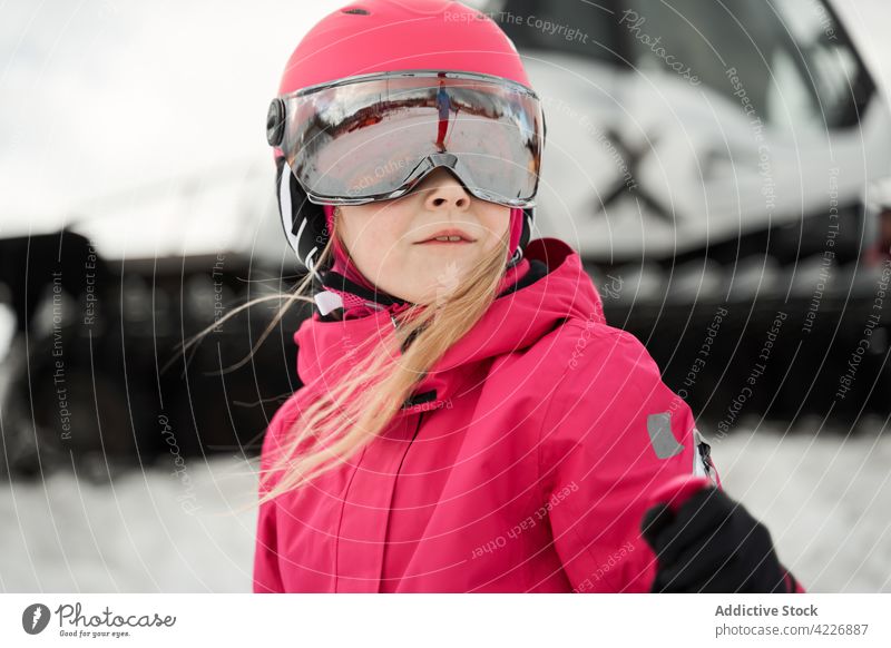 Mädchen mit Helm beim Skifahren auf einer verschneiten Piste Aktivität Sportkleidung Schutzhelm Hobby Vitalität Berghang Energie Winter Entwicklung physisch