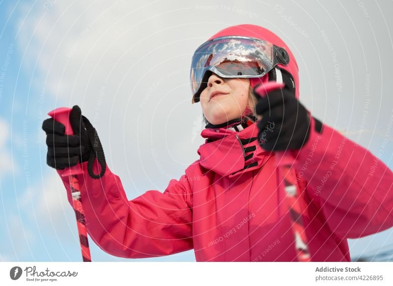 Zufriedenes Mädchen mit Helm beim Skifahren auf einer verschneiten Piste Aktivität Sportkleidung Schutzhelm Hobby Vitalität Berghang Energie Winter Entwicklung
