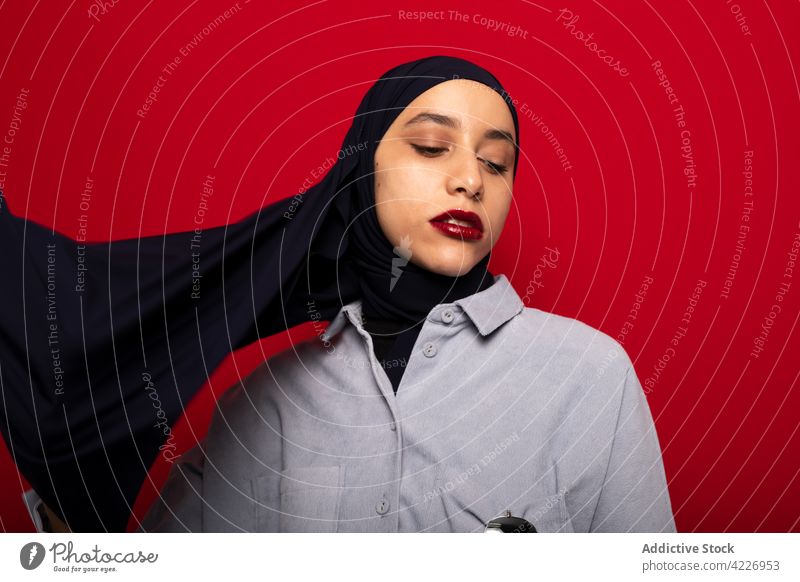 Muslimische Frau mit modischem Kopftuch im Studio muslimisch Hijab Stil Körperhaltung Kopfschmuck Kultur feminin bescheiden authentisch Vorschein Tradition jung