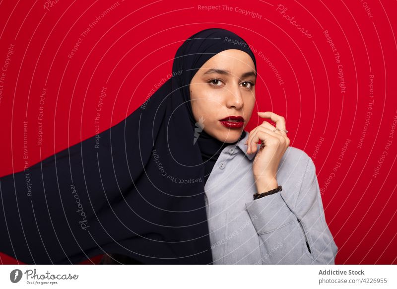 Muslimische Frau mit modischem Kopftuch im Studio muslimisch Hijab Stil Körperhaltung Kopfschmuck Kultur feminin bescheiden authentisch Vorschein Tradition jung