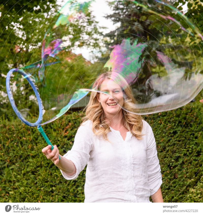 Magie der Seifenblasen Junge Frau Spielerei spielerisch Spass spaßig Spaß Spaß haben Fröhlichkeit Außenaufnahme Sommer Farbfoto Riesenseifenblase