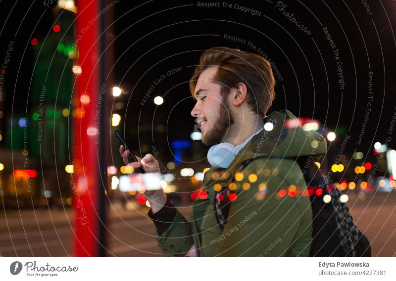 Junger Mann mit Smartphone auf städtischen Straße in der Nacht männlich Schüler Tourist urban Großstadt Menschen junger Erwachsener lässig Kaukasier genießend