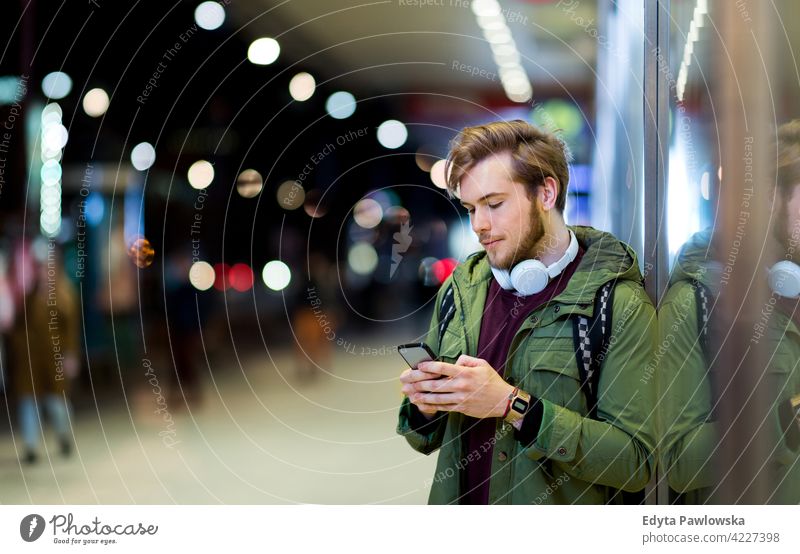 Junger Mann mit Smartphone auf städtischen Straße in der Nacht männlich Schüler Tourist urban Großstadt Menschen junger Erwachsener lässig Kaukasier genießend