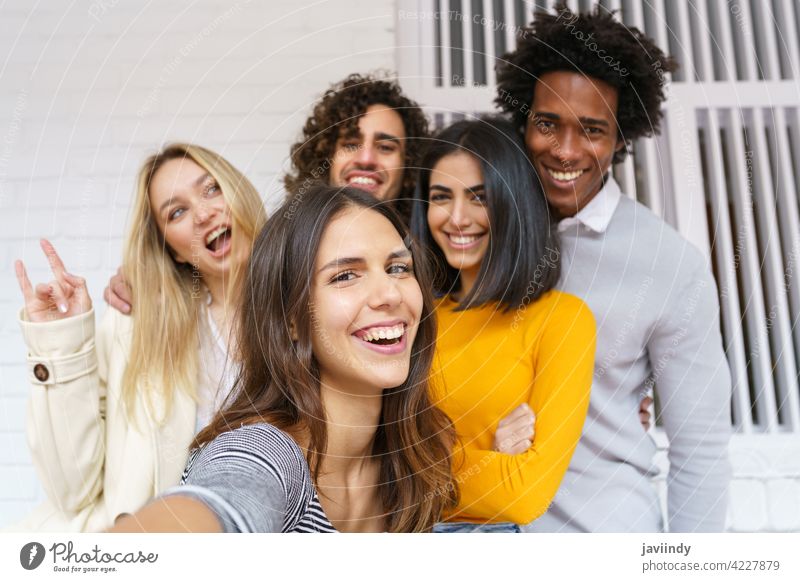 Multi-ethnische Gruppe von Freunden, die zusammen ein Selfie machen, während sie Spaß im Freien haben. Menschengruppe Smartphone rassenübergreifend