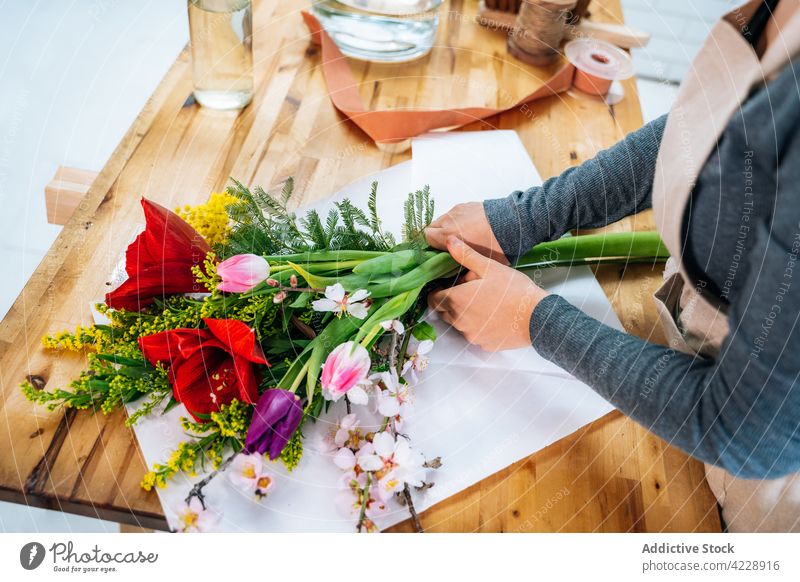 Anonyme Blumenhändlerin bei der Herstellung einer Komposition mit verschiedenen frischen Blumen Frau Blumenstrauß Arbeit Pflanze geblümt Arbeitsplatz Ordnung