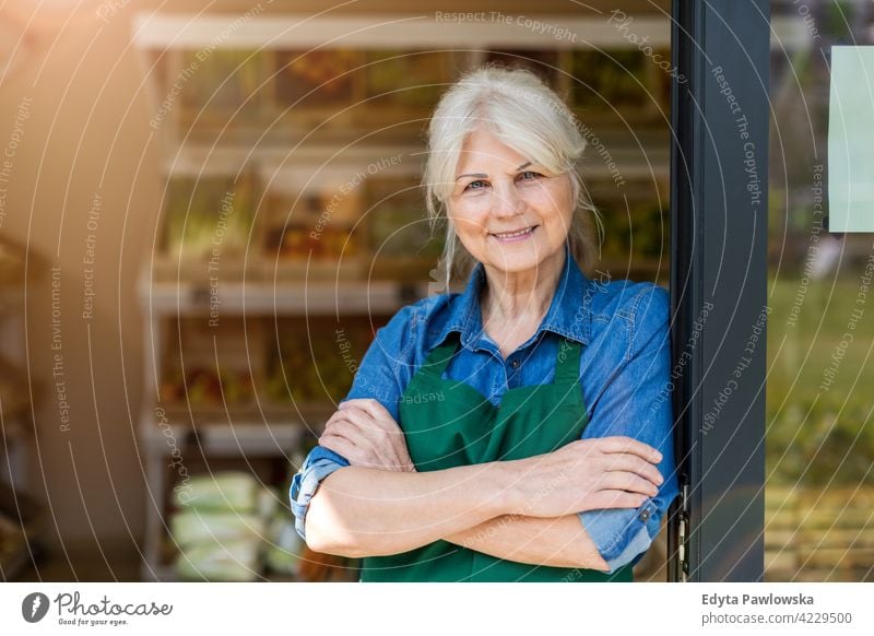 Ältere Frau arbeitet in einem kleinen Lebensmittelladen Lebensmittelhändler Gemüsehändler Lebensmittelgeschäft Menschen Senior reif Erwachsener lässig attraktiv