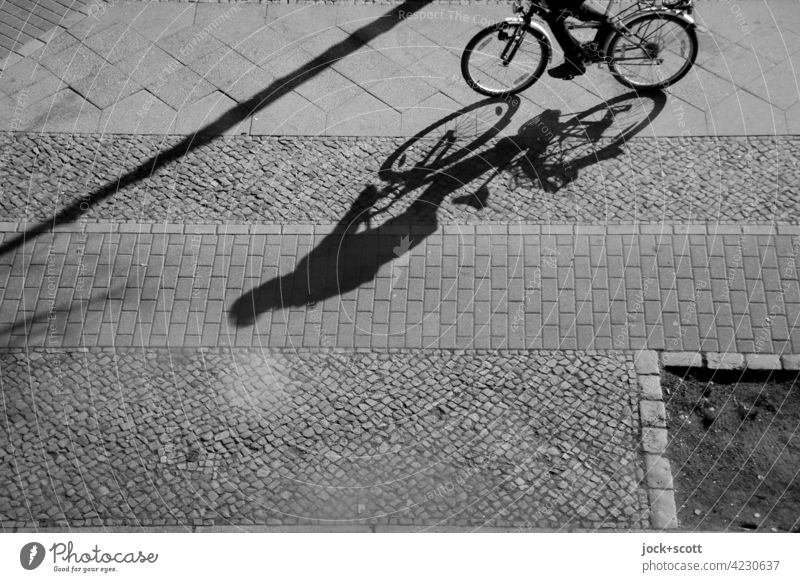Rad fahren auf dem Gehweg Bürgersteig Schlagschatten Sonnenlicht Silhouette Schattenspiel Strukturen & Formen Wege & Pfade Pflastersteine Bodenplatten