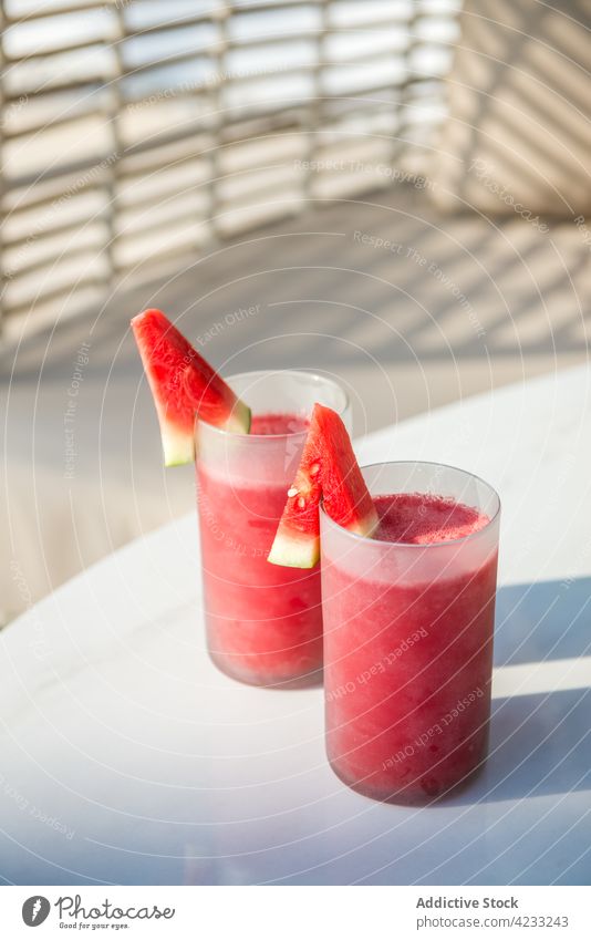 Gläser mit appetitlichen Wassermelonensäften auf dem Tisch im Innenhof Smoothie frisch Saft Erfrischung Gesundheit patio Sofa Getränk Vitamin trinken natürlich