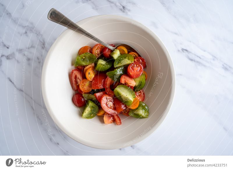 Flacher, frischer, bunter Tomatensalat in einer weißen Schale, vegan, vegetarisch Lebensmittel Fotografie essen Koch Küchenchef geschmackvoll schön Löffel