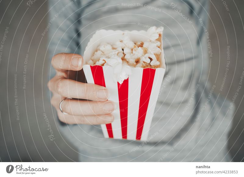 Frau hält einen Behälter voll mit Popcorn Mais Kino Filmmaterial altehrwürdig retro klassisch stilvoll rot weiß Versuchung Snack genießen Hand Lifestyle Leben