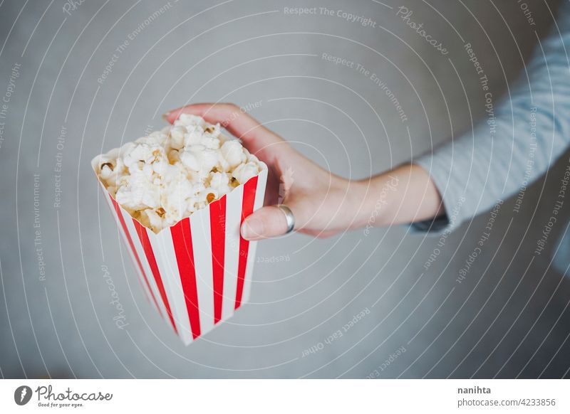 Frau hält einen Behälter voll mit Popcorn Mais Kino Filmmaterial altehrwürdig retro klassisch stilvoll rot weiß Versuchung Snack genießen Hand Lifestyle Leben