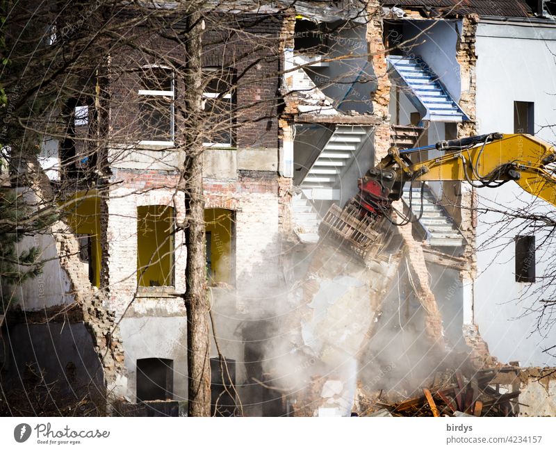 Abrissbagger bei der Arbeit. Abriss einer Häuserzeile, Abbrucharbeiten von Wohnhäusern, Staubentwicklung Abrissgebäude Abrissarbeiten Zerstörung Altbau kaputt
