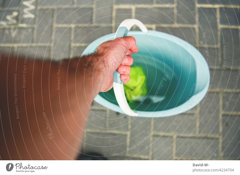 Putztag - Hand hält einen Putzeimer Eimer halten Lappen Putzlappen Wasser sauber machen Reinigen fleißig putzen