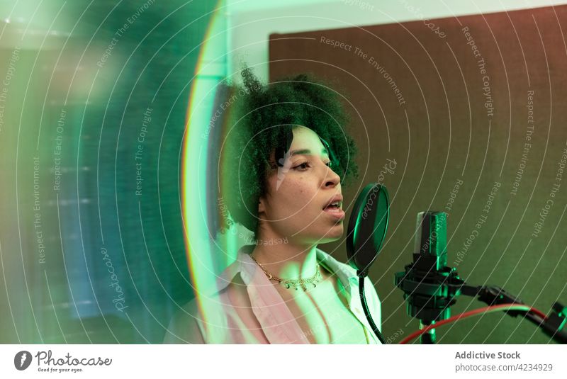 Afroamerikanischer Sänger, der im Aufnahmestudio ein Lied ins Mikrofon singt Gesang Aufzeichnen Musik professionell Atelier Frau Sängerin singen Pop-Filter