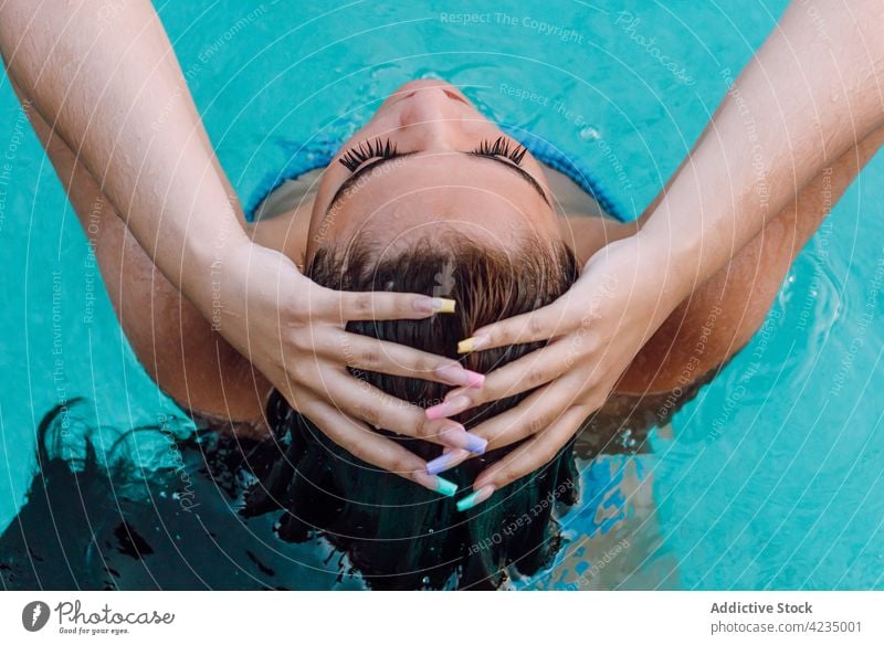 Rückenansicht weibliche Tourist in Badebekleidung berühren nassen Haare im Pool mit reinem Wasser im Urlaub Reisender Haare berühren Augen geschlossen genießen