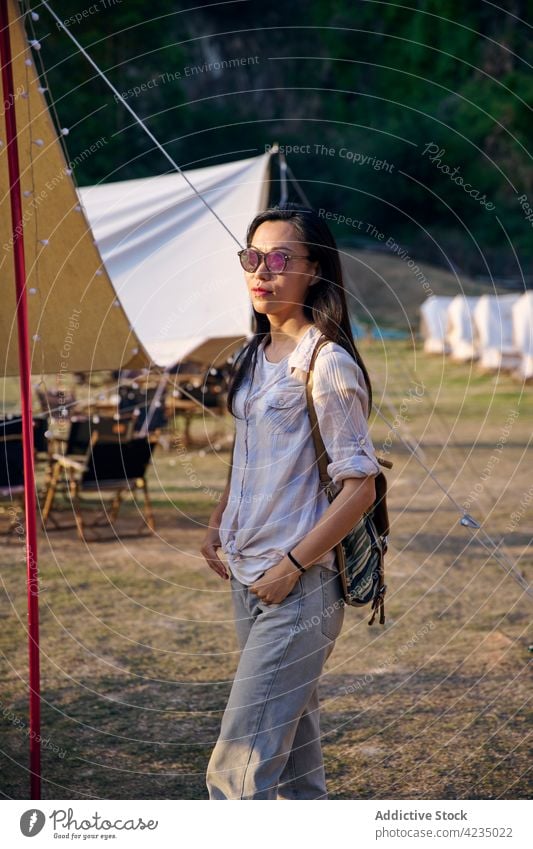 Asiatische Frau beim Entspannen auf dem Campingplatz Zelt Model asiatisch Chinesisch ethnisch eine Person selbstbewusst genießen sich[Akk] entspannen sonnig