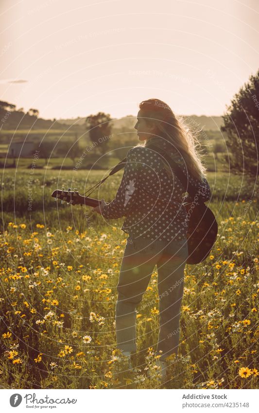 Anonyme Frau spielt Gitarre in der Natur Sommer Spielen Landschaft Hipster Musiker Träumer Sommerzeit nachdenklich Lifestyle romantisch stehen Wiese Urlaub
