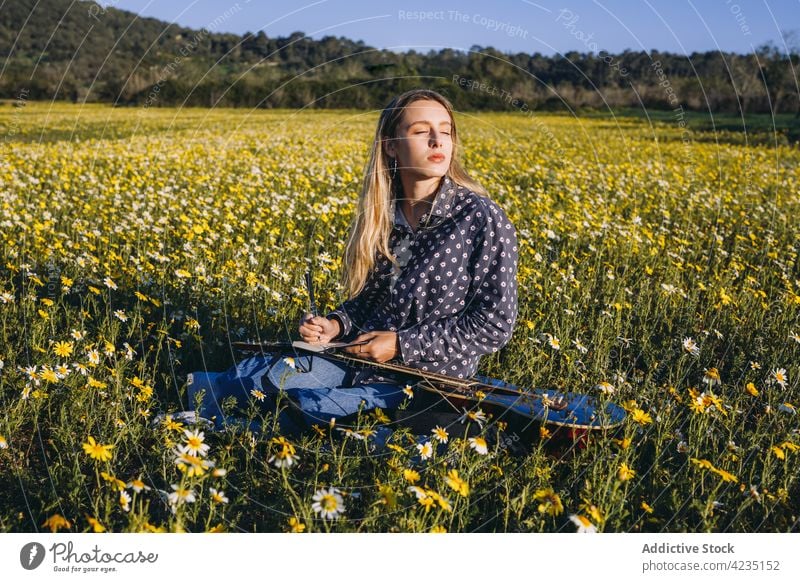 Junge Frau spielt Gitarre in der Natur Sommer Spielen Landschaft schreiben Hipster Musiker Träumer Augen geschlossen Notebook Sommerzeit Lifestyle romantisch