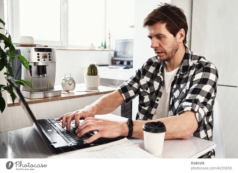 Mann arbeitet im Home Office mit Laptop und Dokumenten Business Büro Arbeitsplatz im Innenbereich Computer Laptop-Geschäft Porträt Geschäftsmann lässig