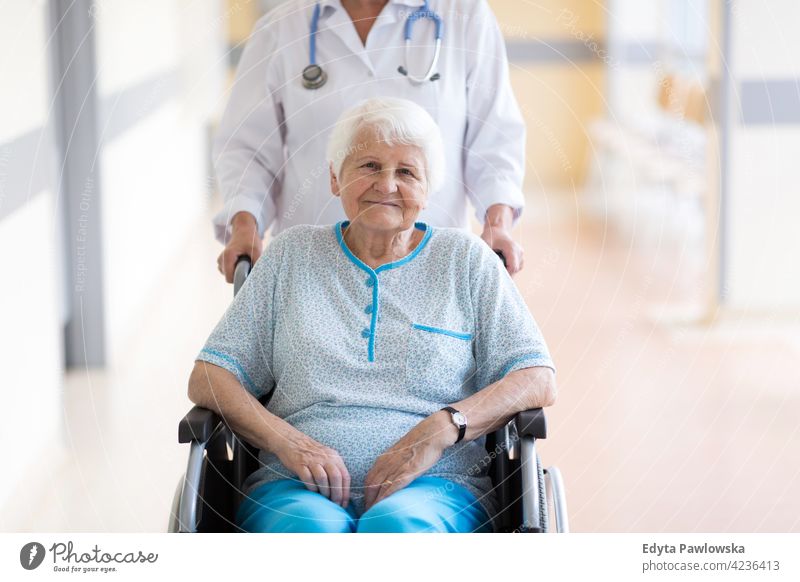 Ältere Frau im Rollstuhl mit Arzt im Krankenhaus rollstuhl Behinderung körperliche Beeinträchtigung Behinderte Mobilität abstützen Zugänglichkeit Objekt Rad