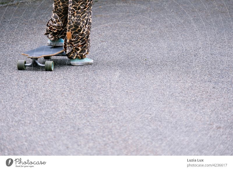 bereit zum Abstoß: ein Mädchen im Faschingskostüm steht auf einem alten Skateboard (Teilansicht) Kostüm Giraffe skurril witzig Zeitgeist fröhlich sportlich wild