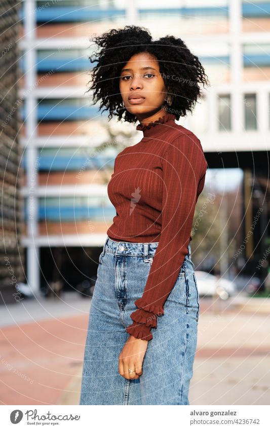 Afroamerikanische Frau steht im Freien auf der Straße. jung Afro-Look schwarz urban Porträt Mode Großstadt lockig Behaarung laufen Kleidung außerhalb