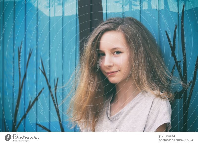 Porträt eines lächelnden Teenager Mädchens mit langen Haaren, 13 Jahre, vor blauem Bauwagen Blick Mensch 8-13 Jahre Lächeln langhaarig Kindheit schön blond