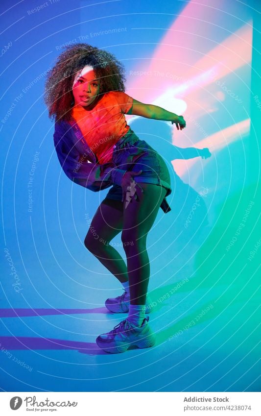 Energetische schwarze Frau tanzt in dunklem Studio Tanzen ausführen cool neonfarbig Tänzer sich[Akk] bewegen Energie Fähigkeit Streetstyle passen Vitalität