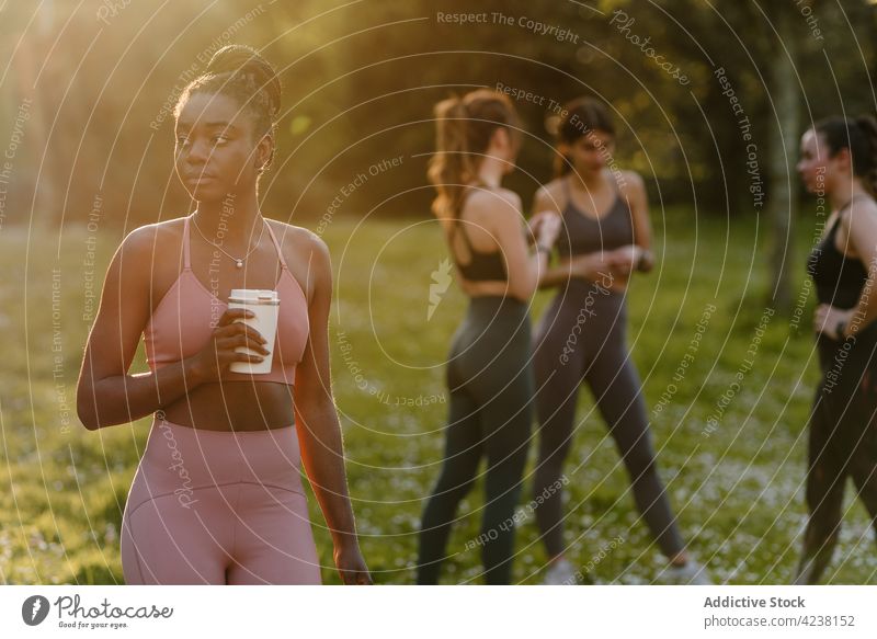 Schwarze Sportlerin mit Becher im Park Tasse trinken Athlet passen Sonnenuntergang Getränk Abend Frau ethnisch schwarz Afroamerikaner Training genießen
